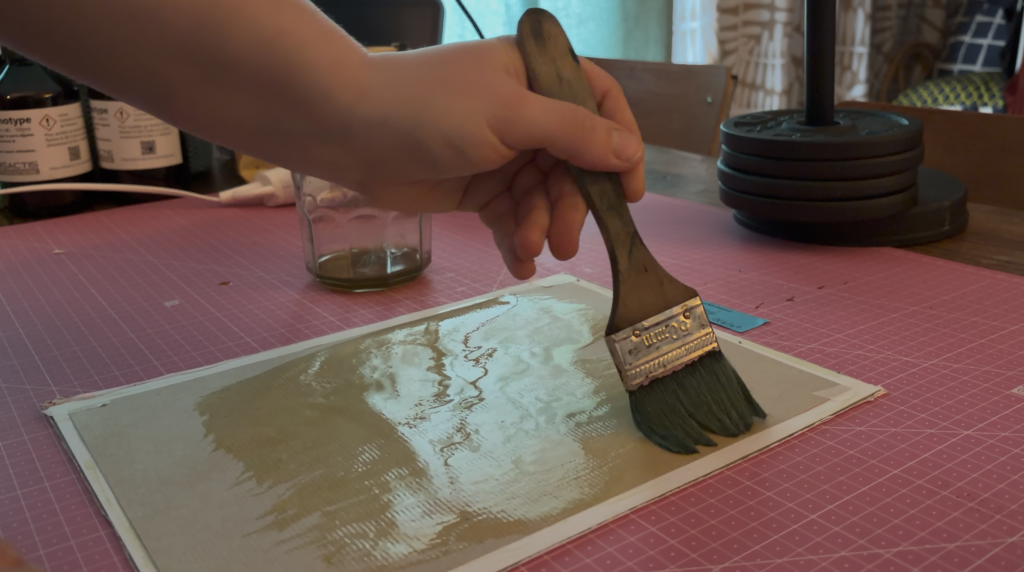 Application de la solution au pinceau large sur l'un des papiers pour le cyanotype