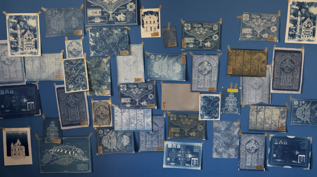 Mur bleu avec des dizaines de feuilles de papiers avec des cyanotypes dessus 